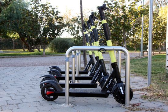 tres patinets en un aparcament