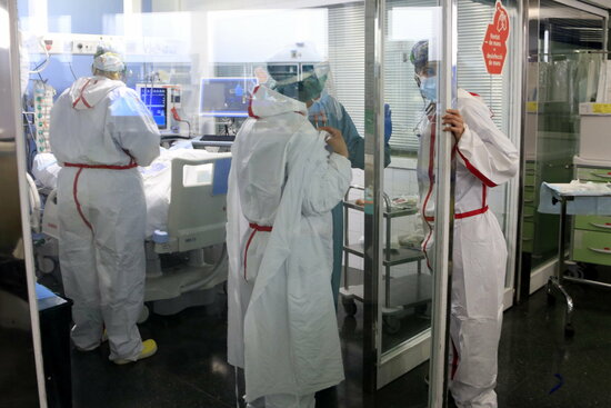 Professionals sanitàries atenent un pacient ingressat a l'UCI amb covid-19. Foto: ACN.