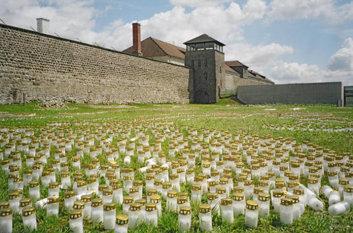 façana de mauthausen amb espelmes al davant en una imatge actual