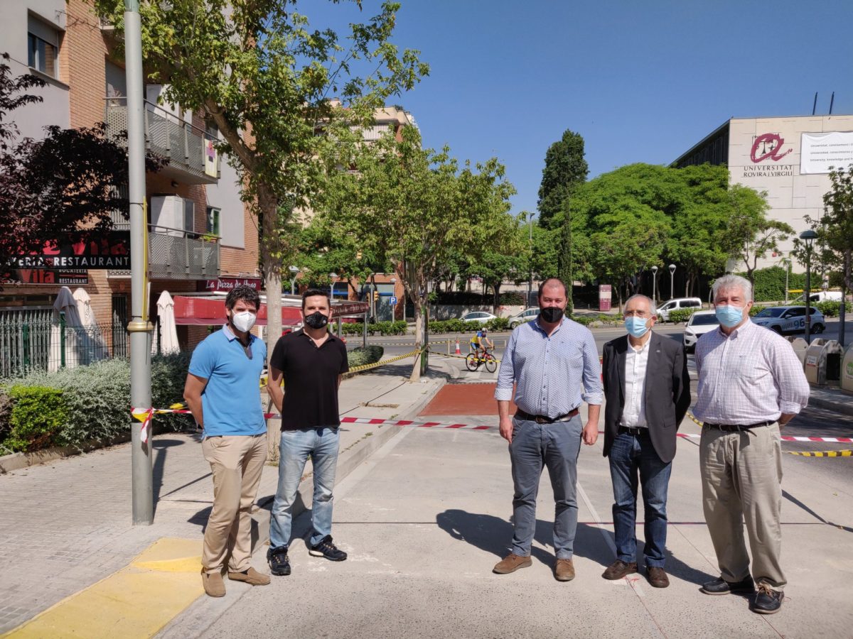 Obres del carril bici amb un vehicle de mobilitat personal passant i amb l'edifici de la URV de fons