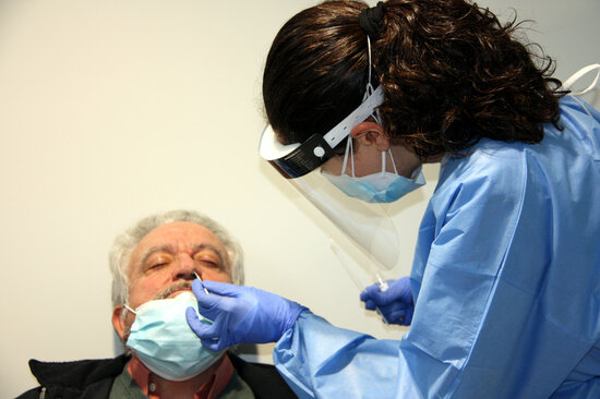 Primer pla d'una sanitària realitzant una PCR a un pacient. Foto: ACN.