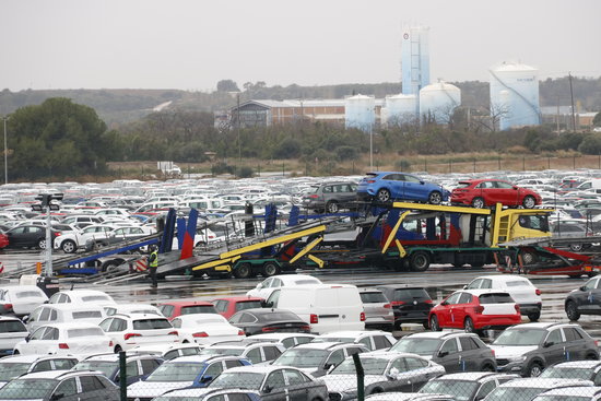 Nombrosos vehicles estacionats a la ZAL del Port de Tarragona, i fàbriques de la indústria química al fons. Foto: ACN.