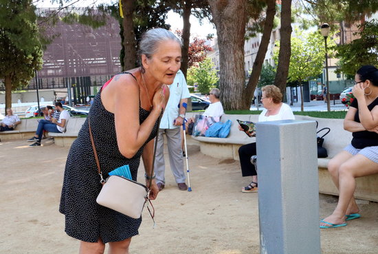 Una dona refrescant-se en una font davant l'onada de calor.