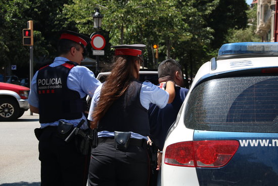 Pla mitjà d'esquena de dos agents dels Mossos d'Esquadra. Foto: ACN.