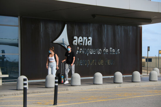 Pla general d'una parella entrant a la terminal de l'Aeroport de Reus. Imatge del 3 d'agost de 2021 (Horitzontal).