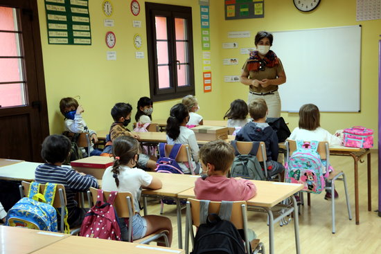 Nens i nenes assegudes al seu pupitre i tots amb mascareta. Foto: ACN.