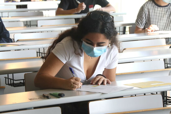 Pla mitjà d'una jove fent les PAU en una aulta del Campus Catalunya de la URV. Foto: ACN.