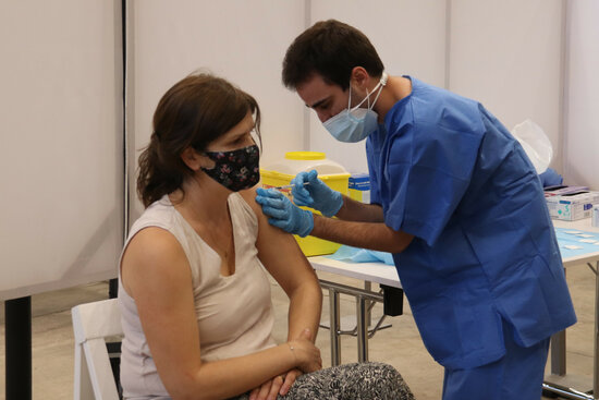 Un infermer administra una vacuna contra la covid-19 a una dona. Foto: ACN.