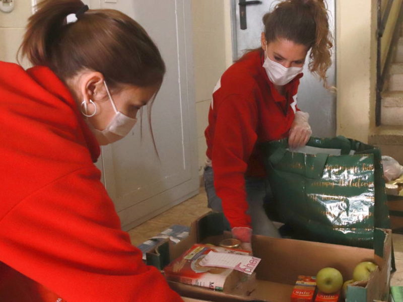 Dues tècniques de Creu Roja Tarragona posant el menjar en bosses de plàstic. Foto: ACN.