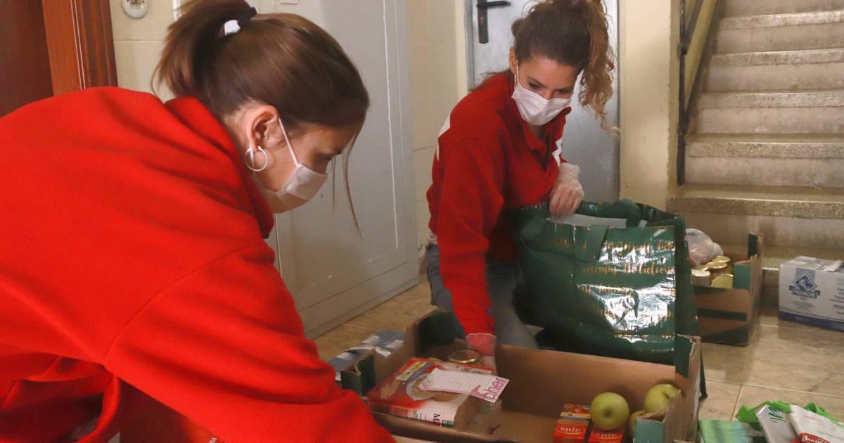 Dues tècniques de Creu Roja Tarragona posant el menjar en bosses de plàstic. Foto: ACN.