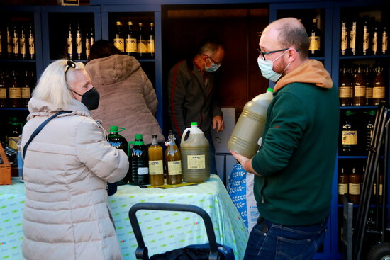 Pla mitjà de dos compradors d'oli a la plaça Corsini.