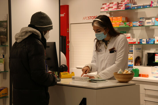 la obert d'una farmacèutica venent un test d'antigen en una farmàcia de Tarragona. Imatge del 24 de desembre del 2021 (Horitzontal).