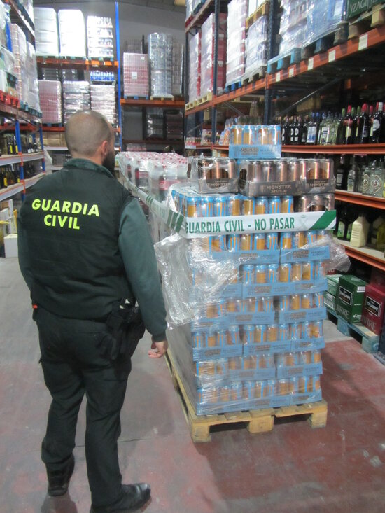 Un agent de la Guàrdia Civil davant dels envasos immobilitzats en un comerç majorista de Tarragona