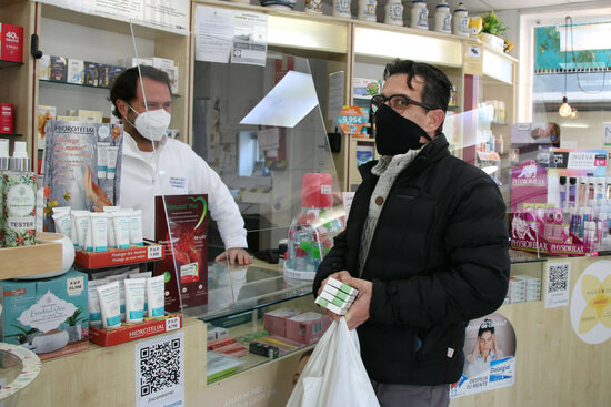 Un usuari comprant tres tests d'antígens en una farmàcia.