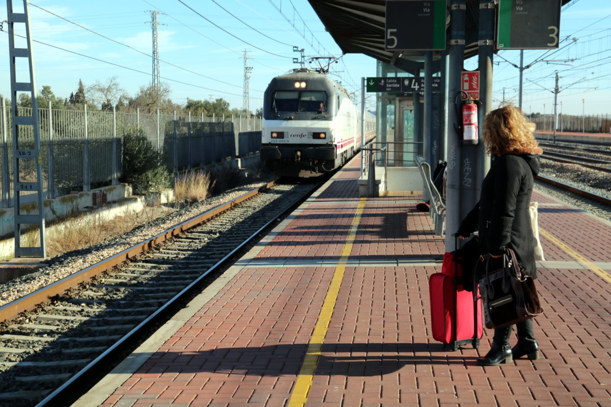 Pla general d'una viatgera esperant a l'andana de l'estació de l'Aldea-Tortosa-Amposta un dels Talgo que ha arribat amb retard. Imatge del 13 de gener del 2020 (horitzontal)